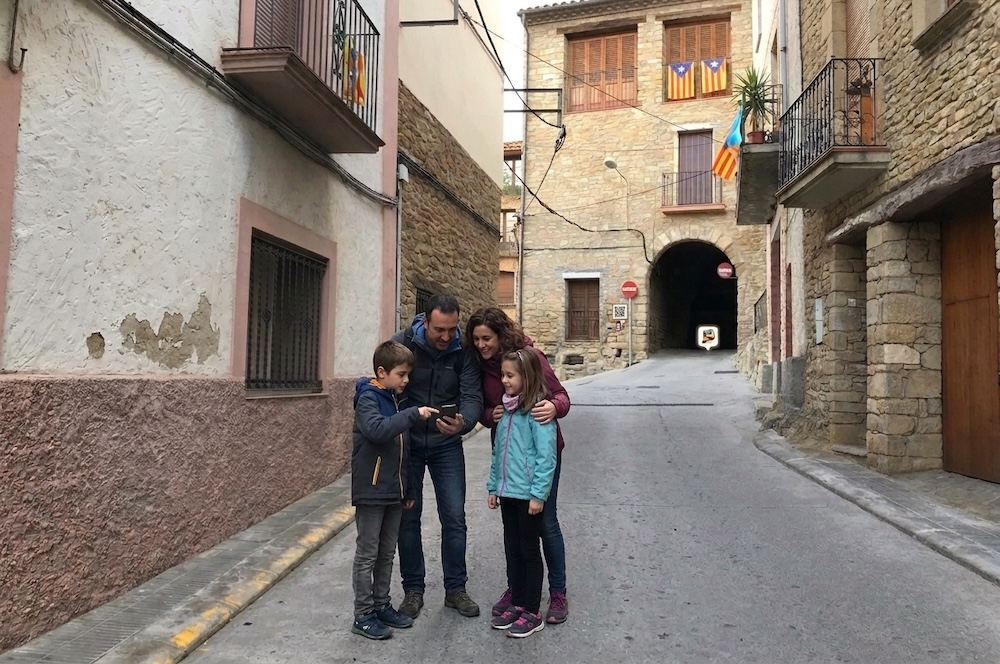 Família jugant al joc de pistes pel poble d'Àger